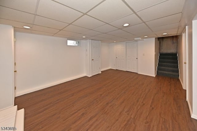 basement with baseboards, stairway, a drop ceiling, recessed lighting, and wood finished floors