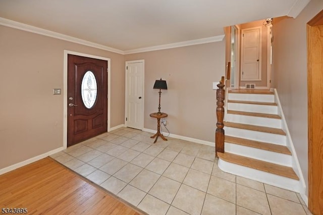 entryway with stairs, crown molding, visible vents, and baseboards