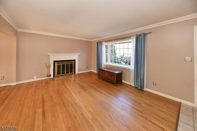 unfurnished living room with baseboards, a fireplace with flush hearth, light wood-style floors, and crown molding