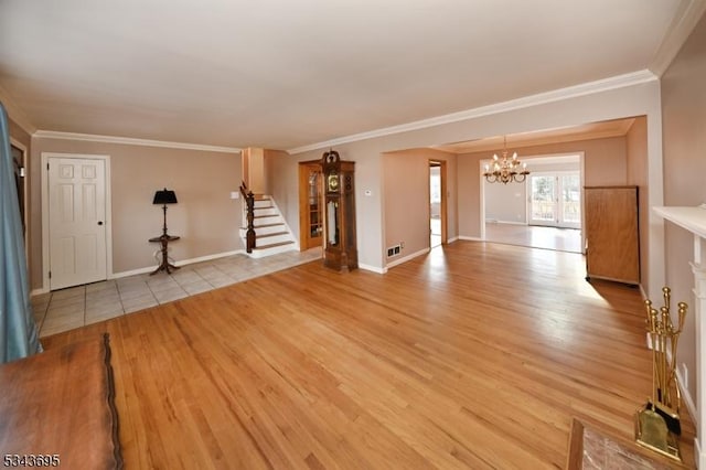 unfurnished living room with visible vents, baseboards, light wood-type flooring, stairs, and an inviting chandelier