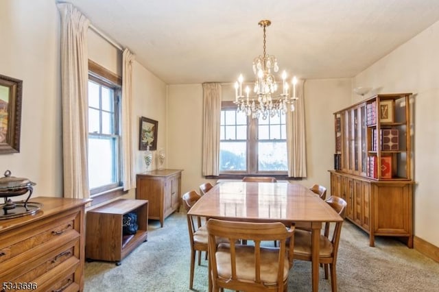 dining space featuring an inviting chandelier, a wealth of natural light, and light carpet