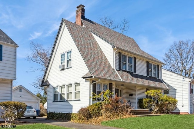 view of front of home featuring a garage, a chimney, and roof with shingles