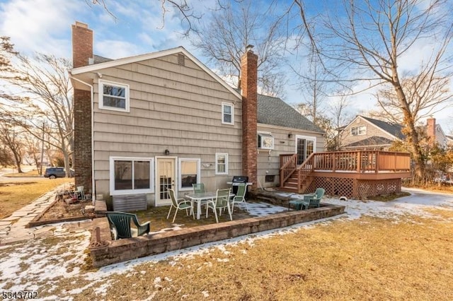 rear view of house featuring a deck, a patio, and a chimney