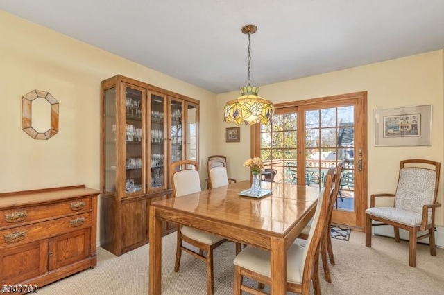 dining room featuring light carpet and a baseboard radiator