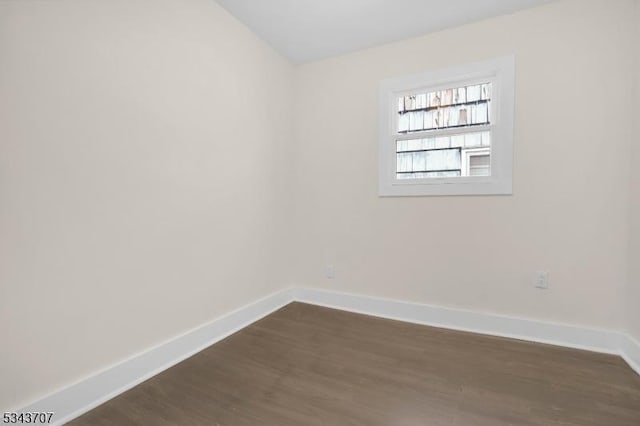 empty room with baseboards and dark wood-style flooring