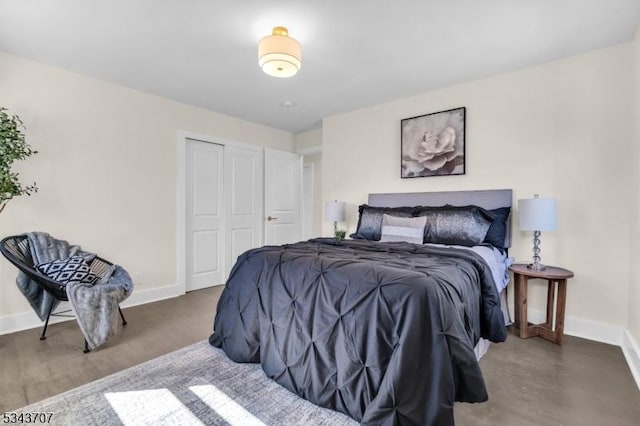 bedroom featuring a closet, baseboards, and wood finished floors