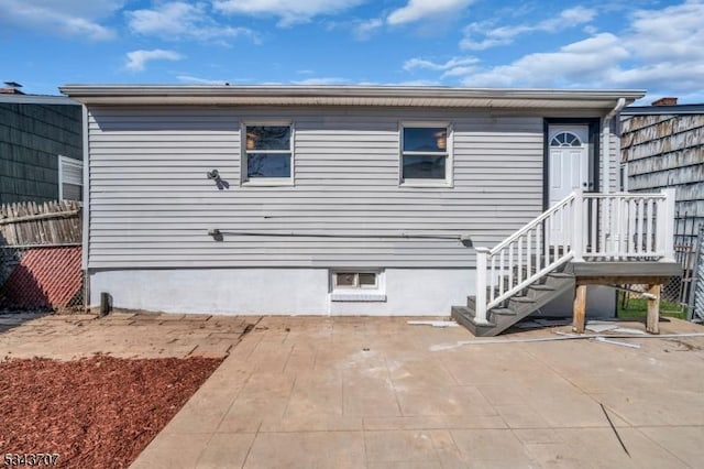 rear view of property with a patio and fence