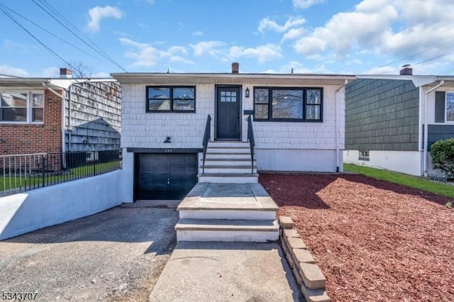 view of front of house with fence, a garage, and driveway