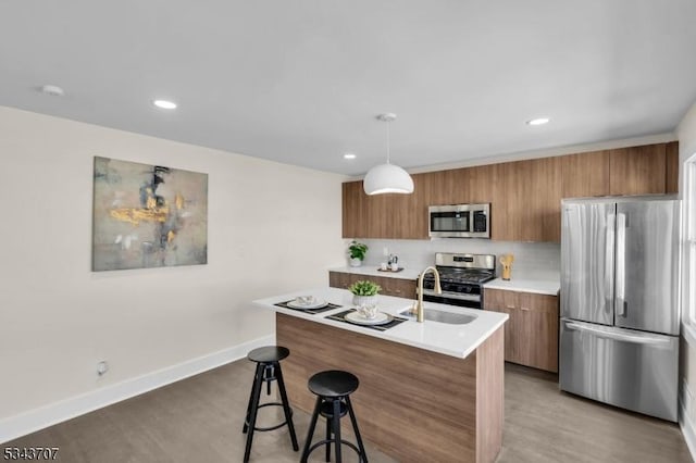 kitchen featuring light wood-type flooring, modern cabinets, appliances with stainless steel finishes, brown cabinetry, and light countertops