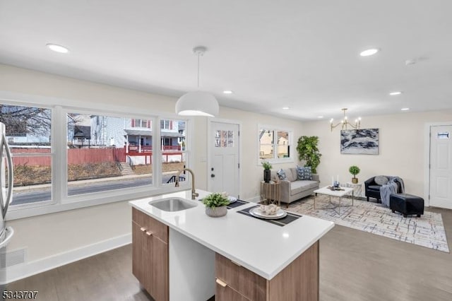 kitchen with open floor plan, a center island with sink, recessed lighting, wood finished floors, and a sink