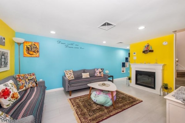 living area with visible vents, a glass covered fireplace, recessed lighting, stairway, and baseboards