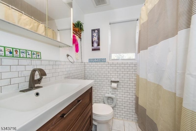 full bath with vanity, visible vents, tile walls, toilet, and tile patterned floors