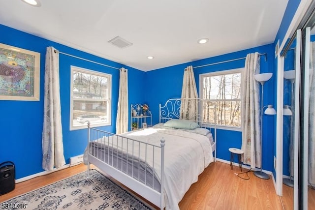 bedroom with recessed lighting, wood finished floors, visible vents, and baseboards