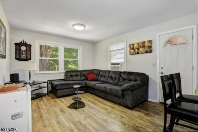 living room with cooling unit and light wood-style flooring