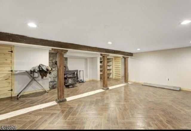 finished below grade area with recessed lighting, baseboards, and a wood stove