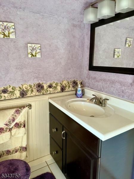 bathroom featuring wallpapered walls, tile patterned floors, and vanity