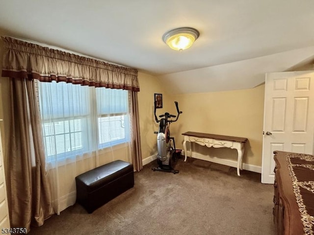 workout area with vaulted ceiling, baseboards, and dark carpet