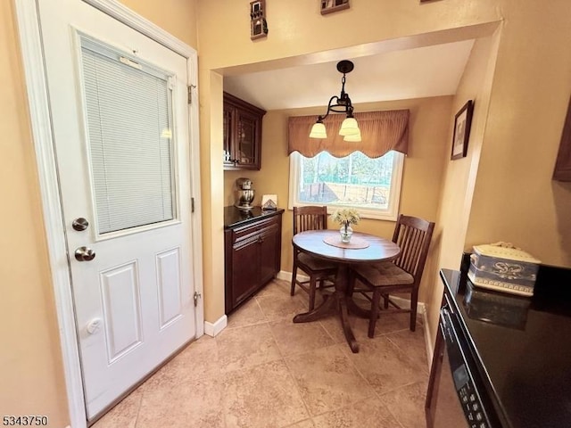 dining area with light tile patterned flooring and baseboards