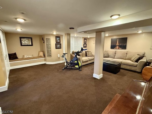 workout room featuring dark carpet and baseboards