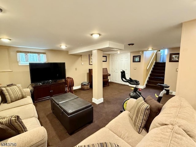 living area featuring stairway, dark carpet, and baseboards