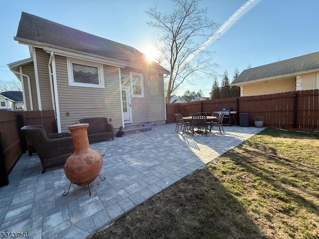 rear view of property with a fenced backyard and a patio