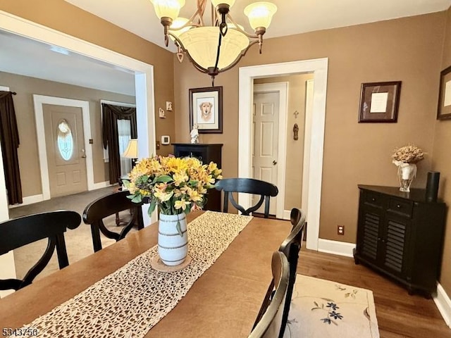 dining area with baseboards and wood finished floors