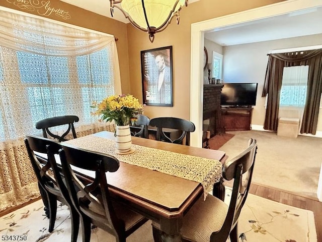 dining space featuring wood finished floors and a fireplace