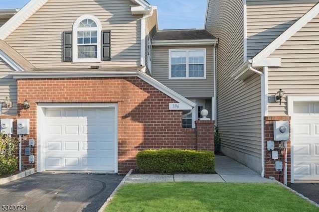 view of front of house featuring an attached garage and brick siding