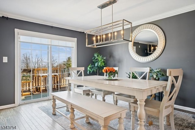 dining space with hardwood / wood-style flooring, baseboards, and ornamental molding