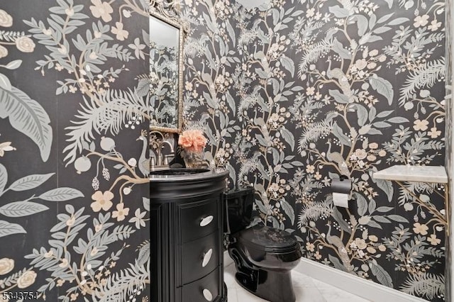 bathroom with toilet, marble finish floor, and vanity