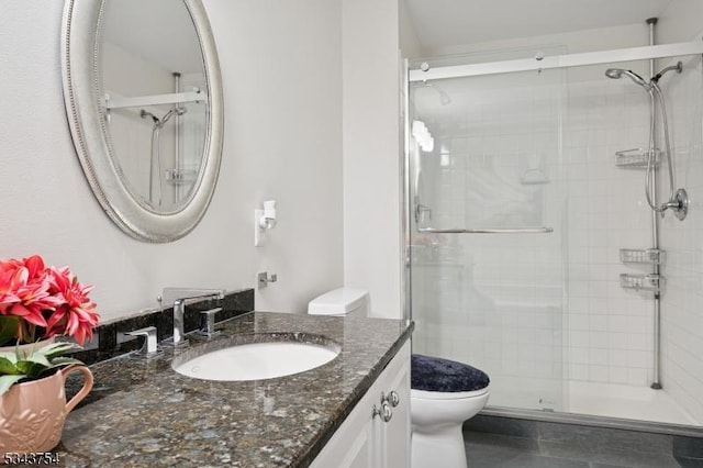 bathroom featuring a stall shower, toilet, and vanity