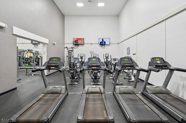 exercise room with a towering ceiling