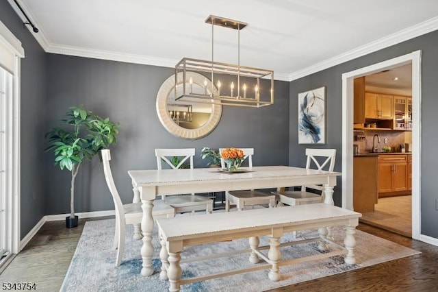 dining room featuring crown molding, a notable chandelier, wood finished floors, and baseboards