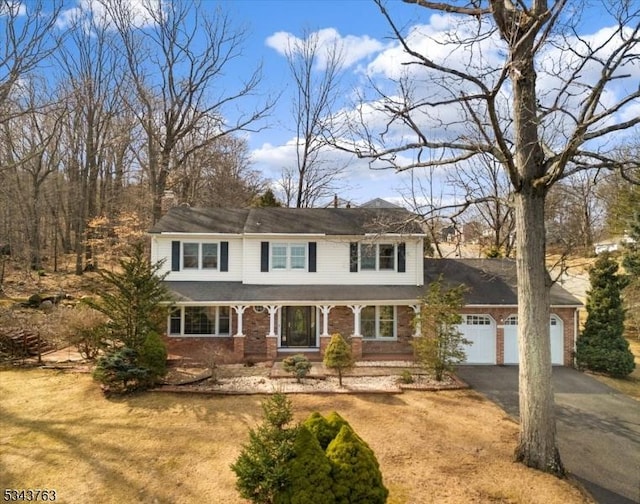 view of front of home featuring aphalt driveway, brick siding, and an attached garage