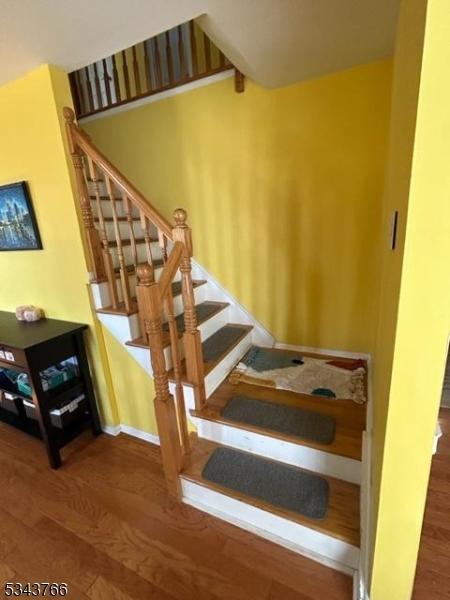 stairway featuring wood finished floors and baseboards