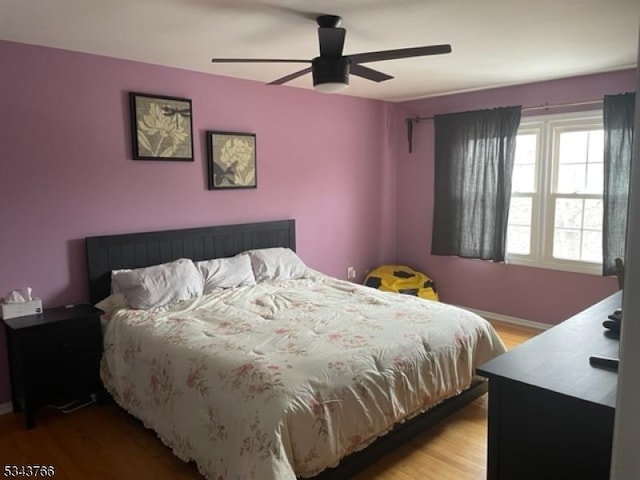 bedroom featuring light wood-type flooring, baseboards, and a ceiling fan