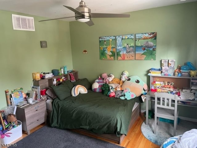 bedroom featuring wood finished floors, visible vents, and ceiling fan