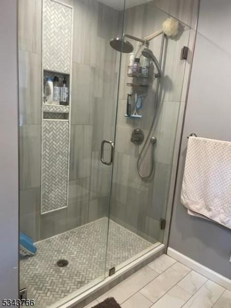 bathroom with a stall shower and baseboards