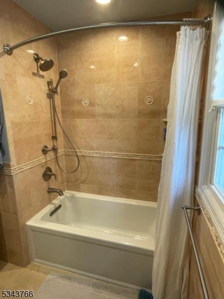 full bath featuring shower / bathtub combination with curtain