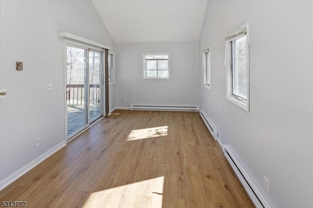 unfurnished room featuring a baseboard radiator, lofted ceiling, and wood finished floors