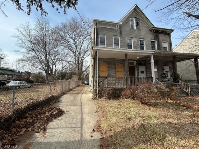 italianate-style house with a porch and fence