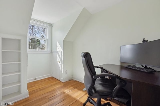 office with light wood-type flooring, baseboards, and vaulted ceiling