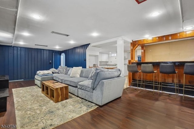 living room with a dry bar and wood finished floors