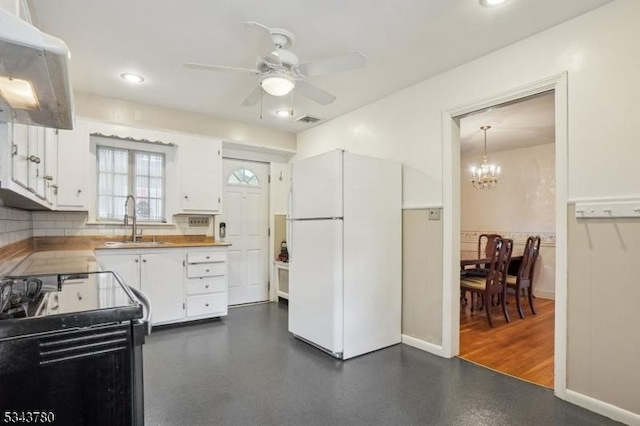 kitchen featuring visible vents, ceiling fan with notable chandelier, freestanding refrigerator, black electric range oven, and white cabinetry