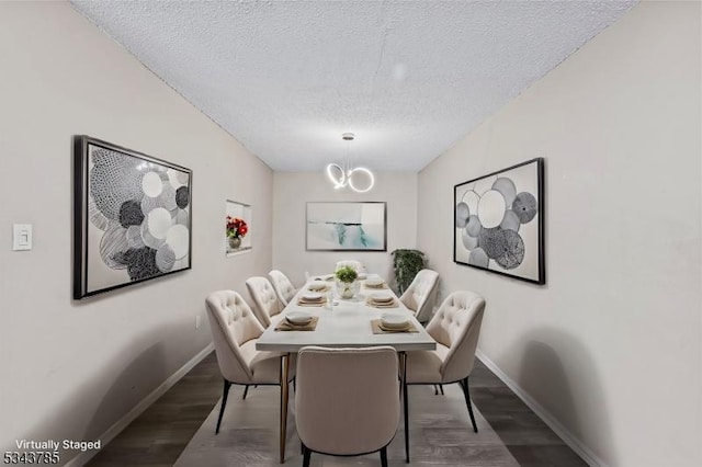 dining area with wood finished floors, baseboards, and a textured ceiling