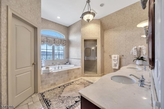 bathroom with a stall shower, vanity, and a garden tub