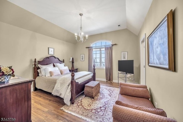 bedroom with baseboards, wood finished floors, a chandelier, and vaulted ceiling