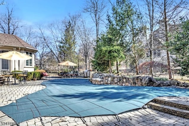 view of swimming pool featuring fence and a patio area