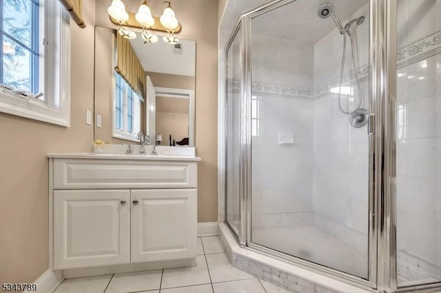 full bathroom featuring tile patterned floors, an inviting chandelier, a stall shower, and vanity