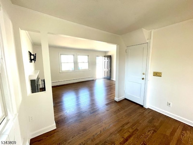 empty room with dark wood-type flooring, baseboards, and a baseboard radiator